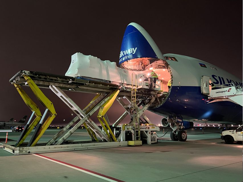 Cargo aircraft loaded through the nose door at night
