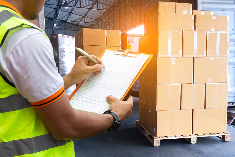 Worker recording pallet details on a manifest at a cross-dock