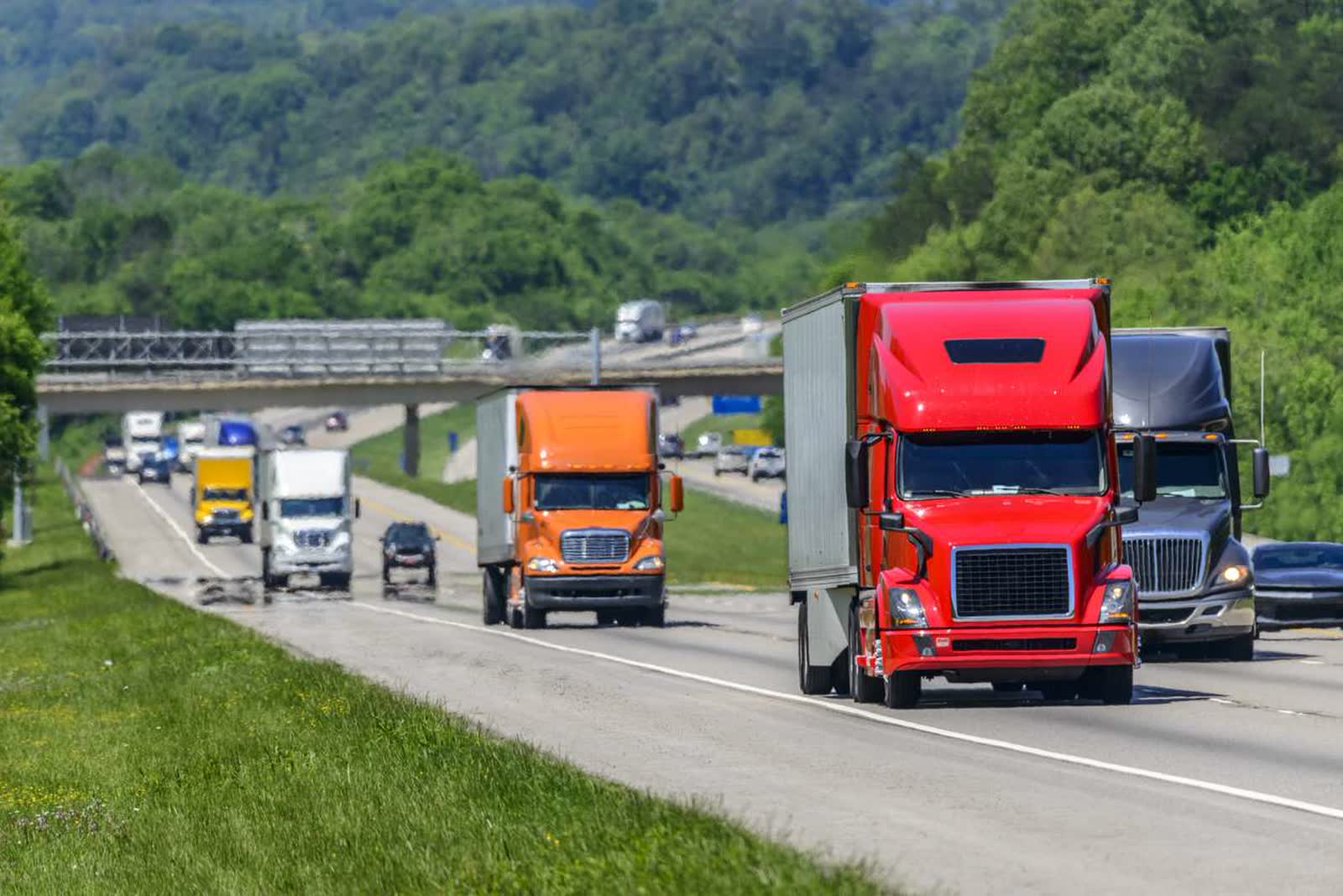 Line of dry van trailers running a multi-lane highway