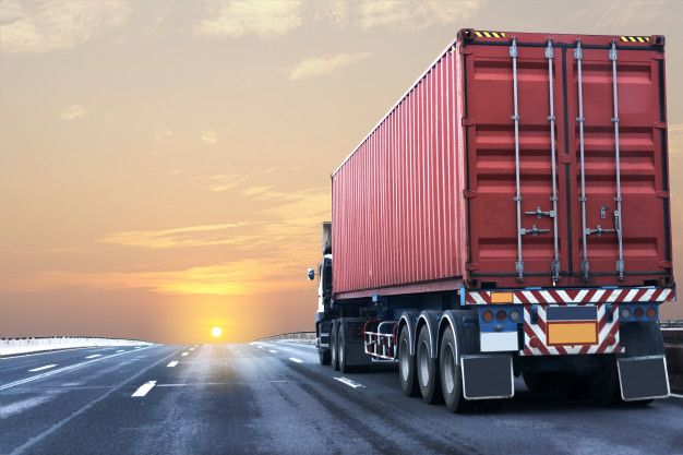 Container truck travelling an open highway at sunset